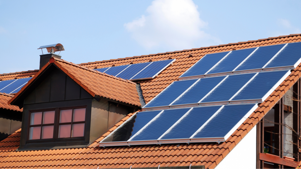 A traditional suburban home with solar panels. The background features a clear blue sky.