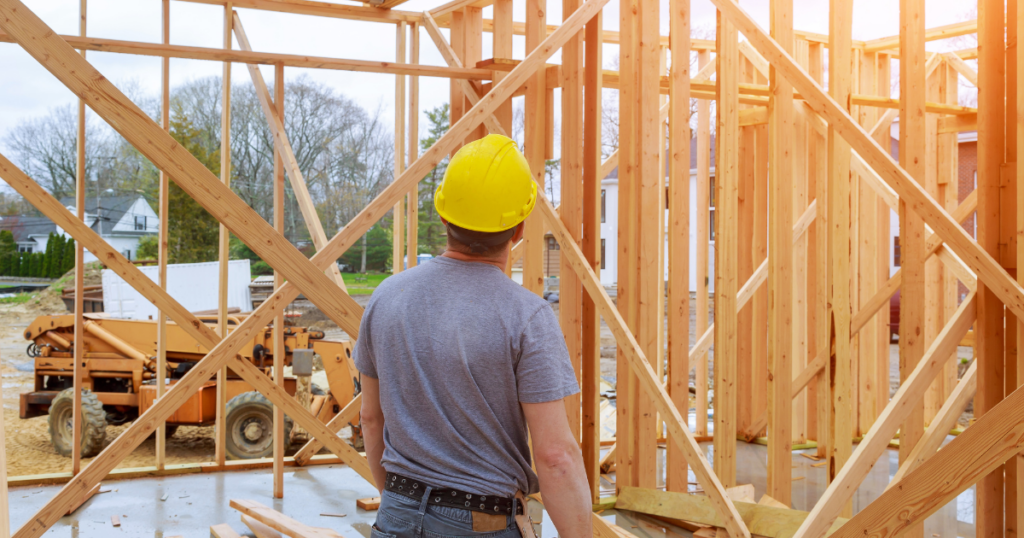 Construction worker inspects new home's wood frame, envisioning future solar installation.