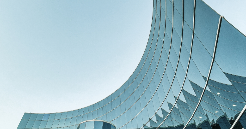 Curved and tall business building with all glass windows.